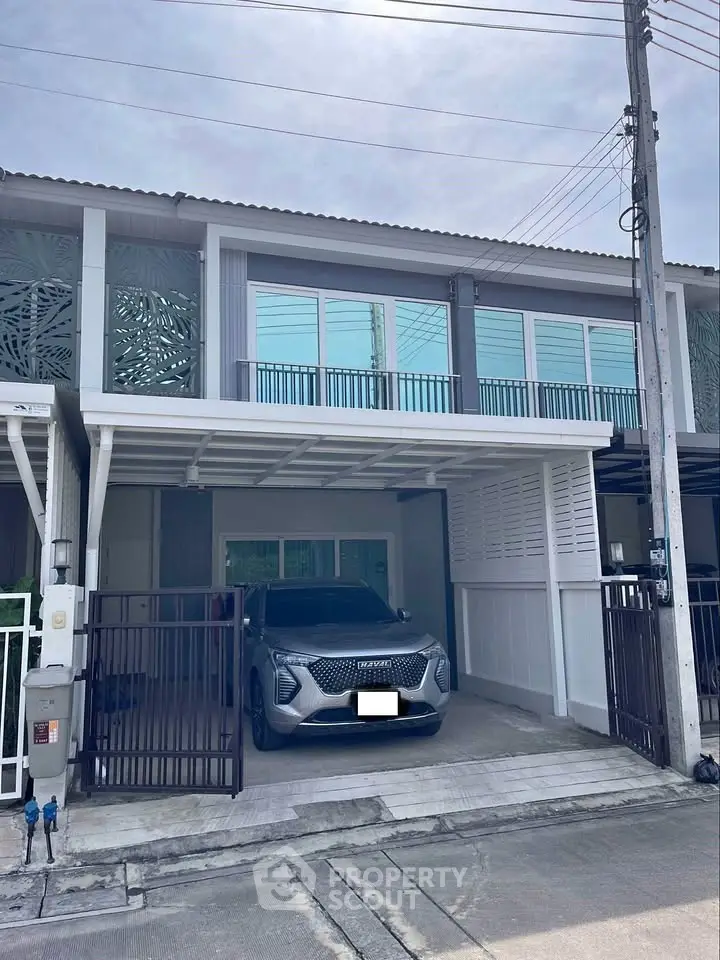 Modern townhouse with carport and stylish facade in suburban neighborhood.