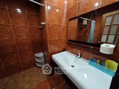 Spacious bathroom with elegant brown tiles and modern fixtures