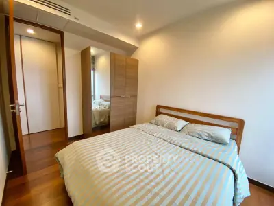 Cozy bedroom with wooden flooring and modern wardrobe in a stylish apartment.