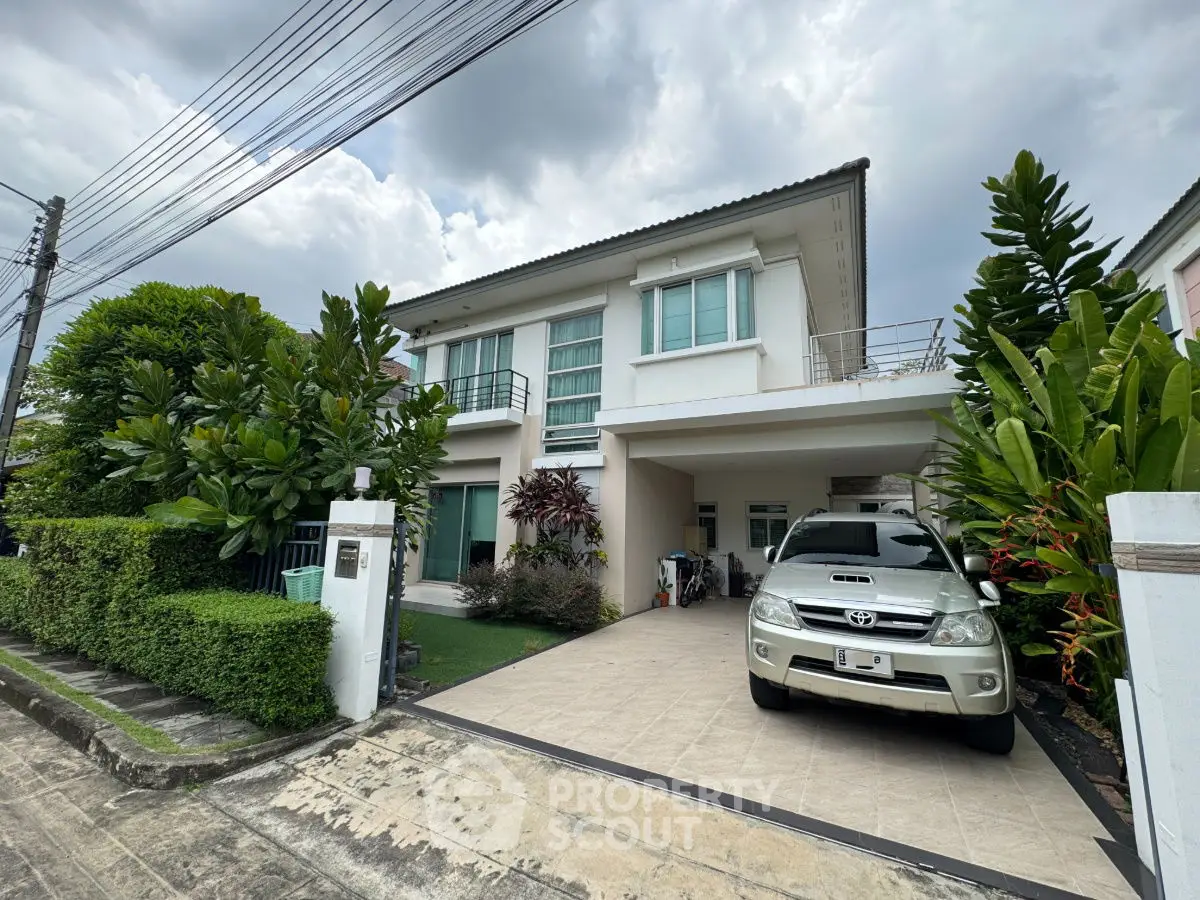 Charming two-story house with lush garden and spacious driveway in serene neighborhood.