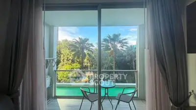 Stunning balcony view with lush greenery and pool, perfect for relaxation and enjoying nature.