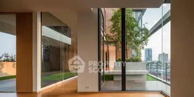 Luxurious modern apartment with floor-to-ceiling windows and private balcony offering stunning city views.