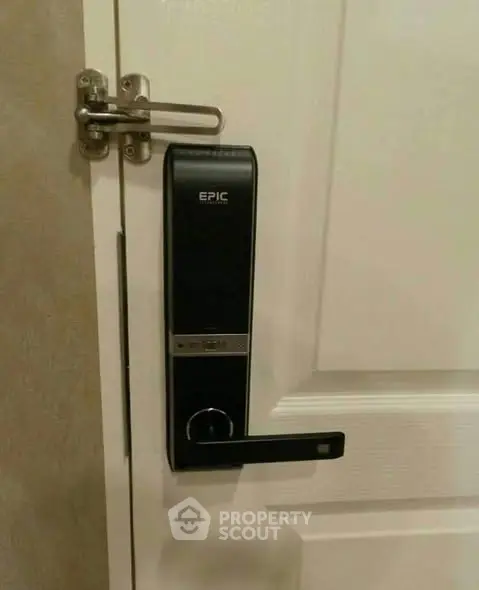 Modern electronic door lock on white interior door for enhanced security.