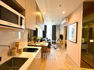 Modern open-layout kitchen and living room with stylish decor and natural light.