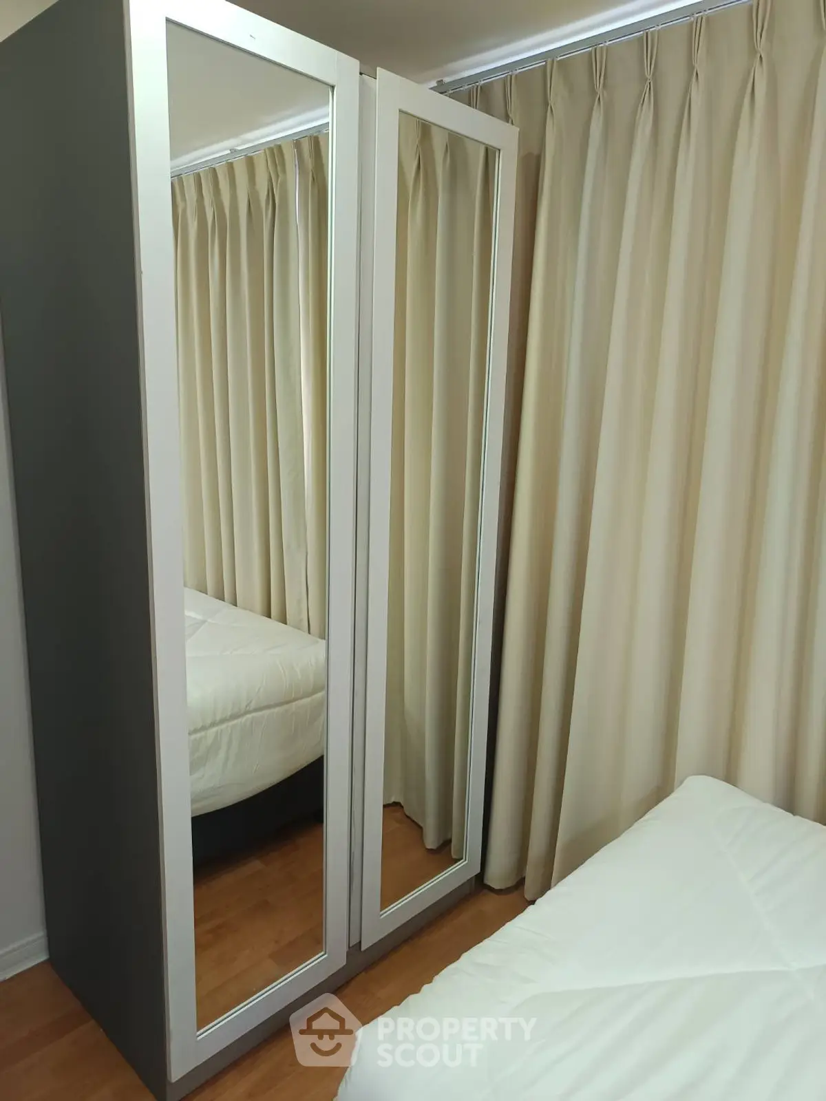 Cozy bedroom with mirrored wardrobe and elegant curtains