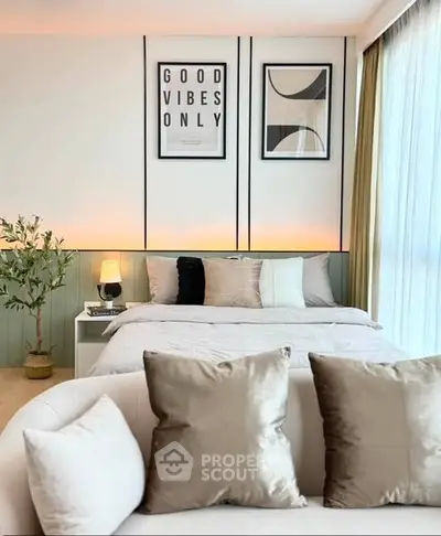 Modern bedroom with stylish decor and cozy seating area, featuring elegant wall art and soft lighting.