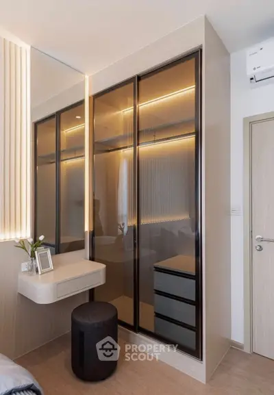 Modern bedroom with sleek wardrobe and stylish vanity area.