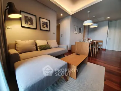 Modern living room with cozy sofa and dining area, featuring elegant wooden flooring and stylish decor.