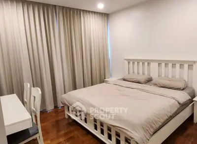 Spacious bedroom with elegant wooden flooring and cozy ambiance