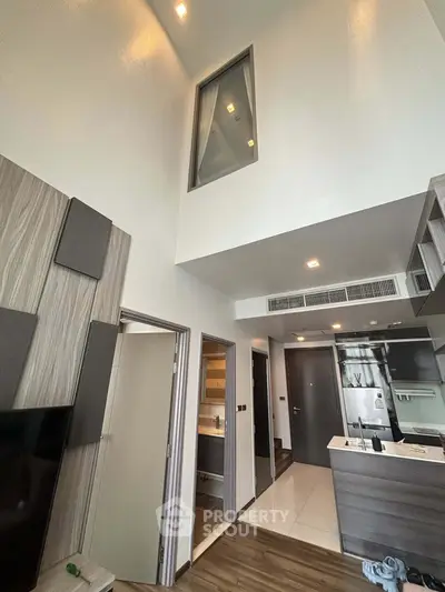 Modern loft-style apartment with high ceilings and sleek kitchen design