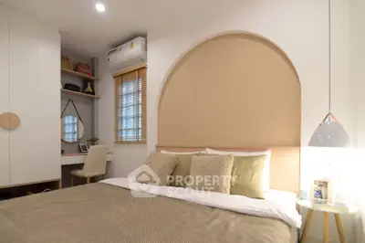 Cozy bedroom with modern decor and soft lighting, featuring a stylish arch accent wall.