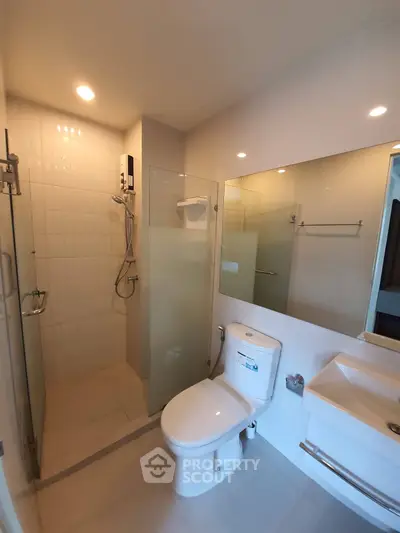 Modern bathroom with glass shower and sleek fixtures in a contemporary apartment.