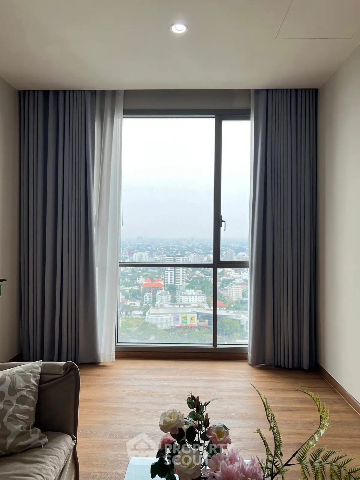Stunning high-rise living room with panoramic city view, elegant decor, and floor-to-ceiling windows.