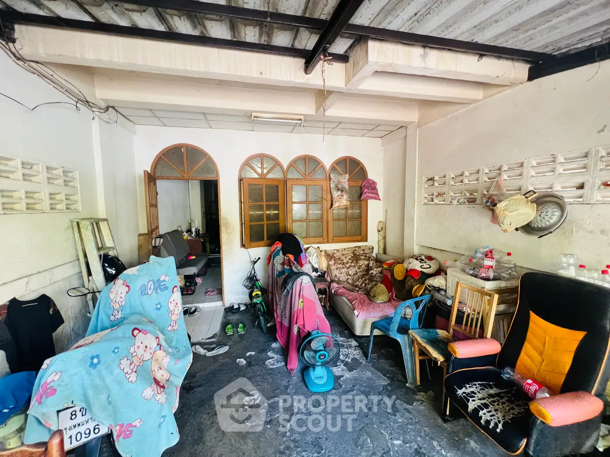 Cozy living area with eclectic furniture and fan, ideal for creative renovation.