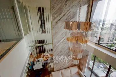 Luxurious high-ceiling living room with stunning chandelier and city view