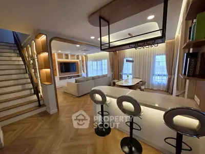 Luxurious open-plan living room with modern kitchen and stylish staircase