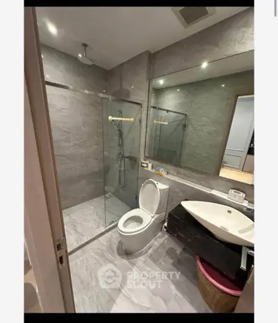 Modern bathroom with glass shower and sleek fixtures in a contemporary home.