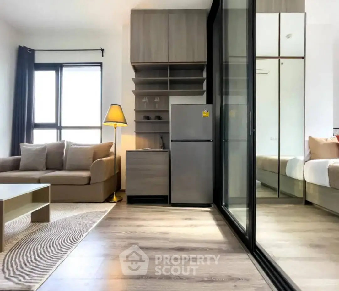 Modern living room with cozy sofa and sleek kitchen area in open layout apartment.