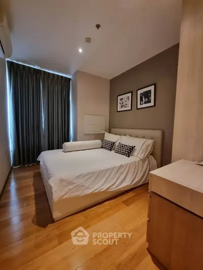 Cozy bedroom with wooden flooring and elegant decor in modern apartment