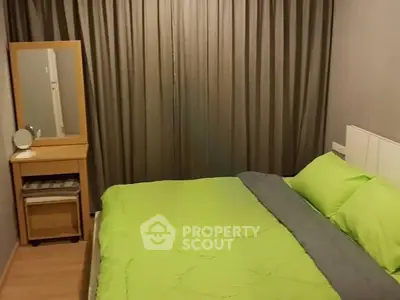 Cozy bedroom with green bedding and elegant curtains, featuring a wooden vanity and mirror.
