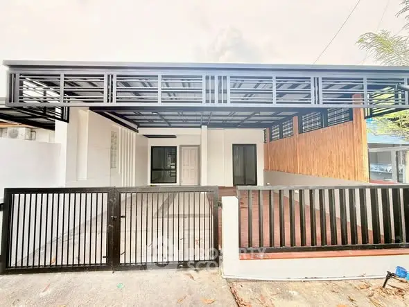 Modern minimalist house exterior with sleek black gate and spacious carport