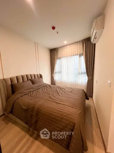 Cozy bedroom with large window and elegant curtains in modern apartment