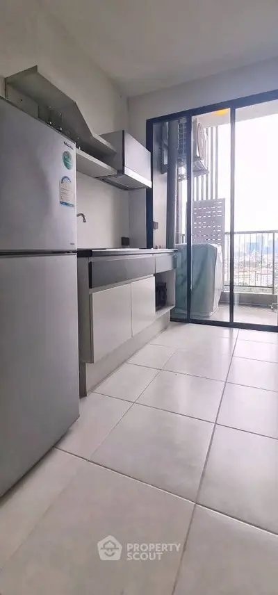 Modern kitchen with sleek cabinetry and balcony access, offering a bright and airy atmosphere.