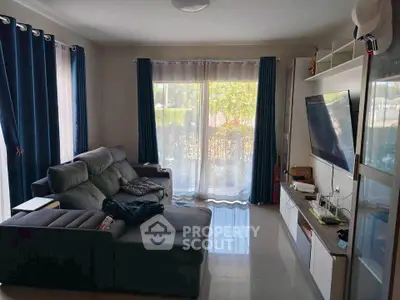 Cozy living room with modern sofa and large TV, perfect for relaxation.