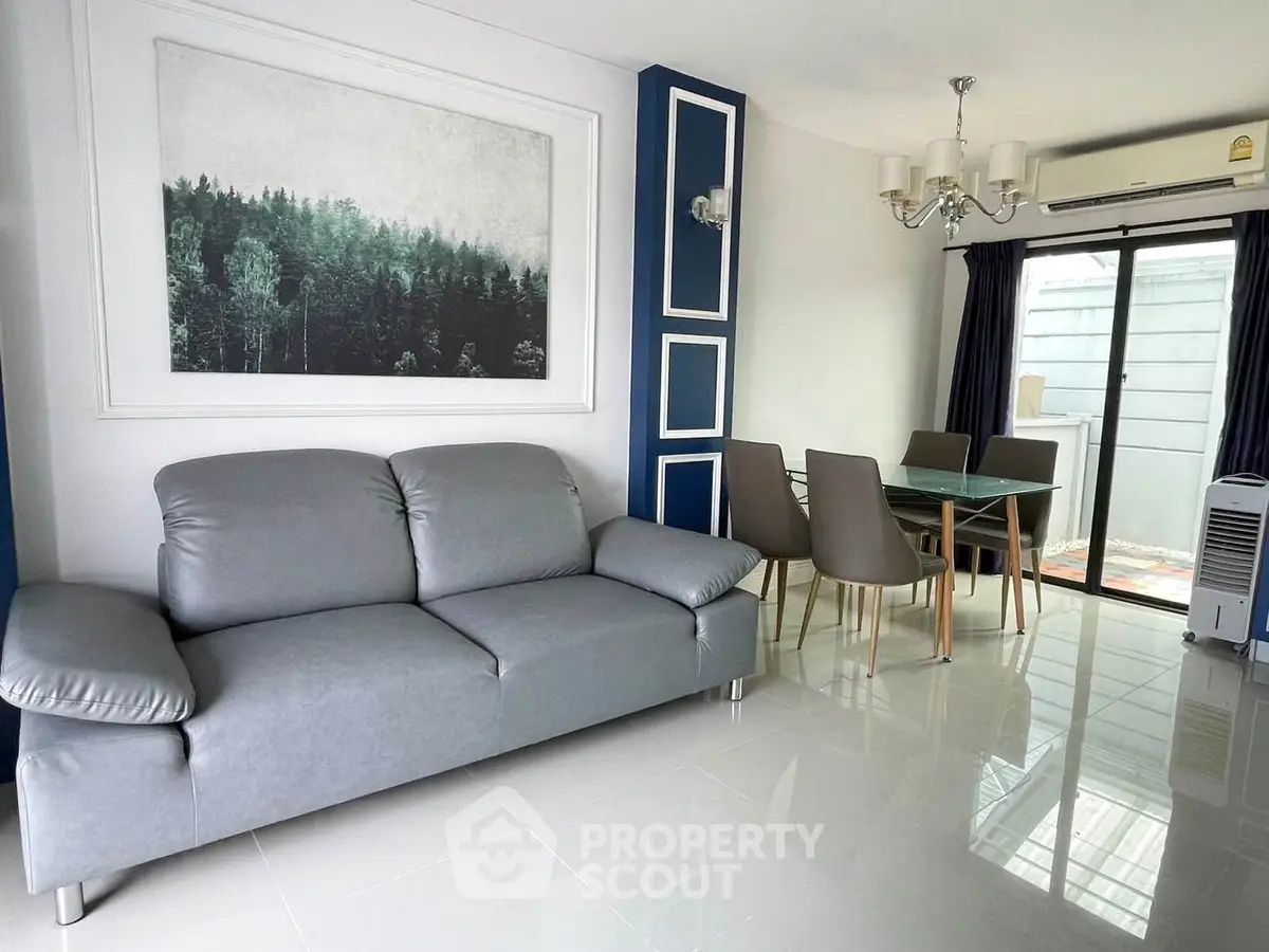Modern living room with sleek gray sofa and elegant dining area