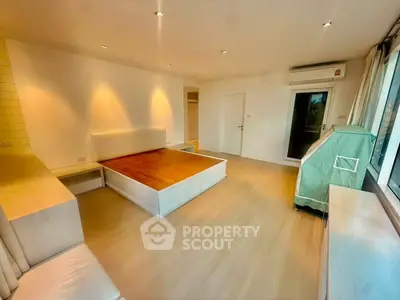Spacious bedroom with modern design and large windows offering natural light.