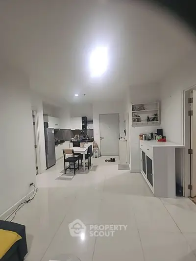 Spacious open-plan kitchen and dining area with modern appliances and sleek white cabinetry.