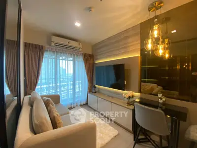 Luxurious living room with modern decor, large TV, and elegant lighting in a high-rise apartment.