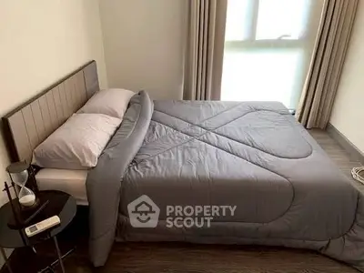 Cozy bedroom with modern decor and natural light, featuring a comfortable bed and stylish side table.