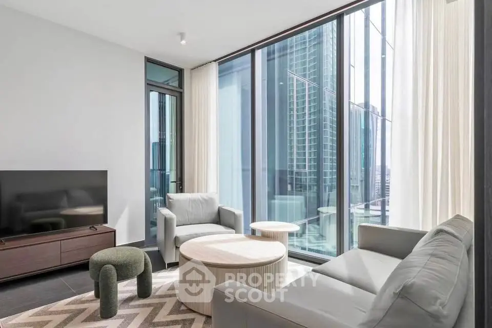 Modern living room with floor-to-ceiling windows and stylish furniture in a high-rise apartment.
