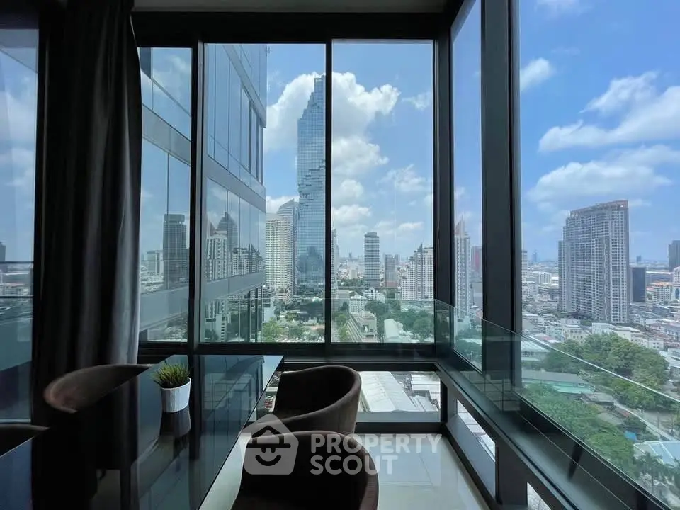Stunning city view from modern high-rise apartment with floor-to-ceiling windows and elegant dining area.