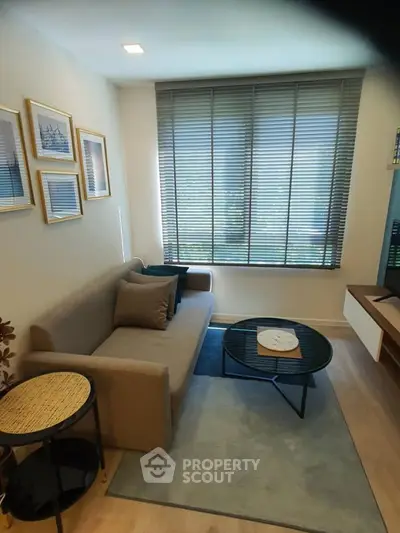 Cozy living room with modern decor and large window blinds