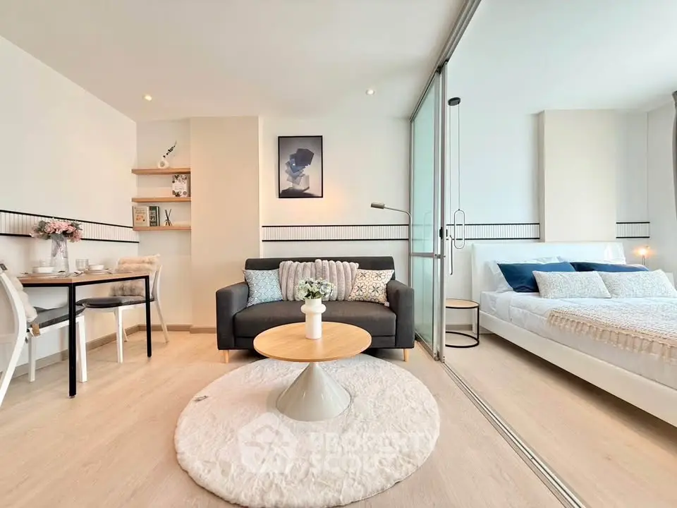 Modern studio apartment with stylish decor and open layout, featuring cozy living area and elegant bedroom.
