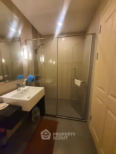 Modern bathroom with glass shower enclosure and sleek fixtures