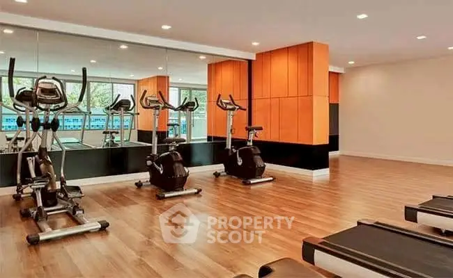 Modern gym with exercise bikes and treadmills in a bright, spacious room.