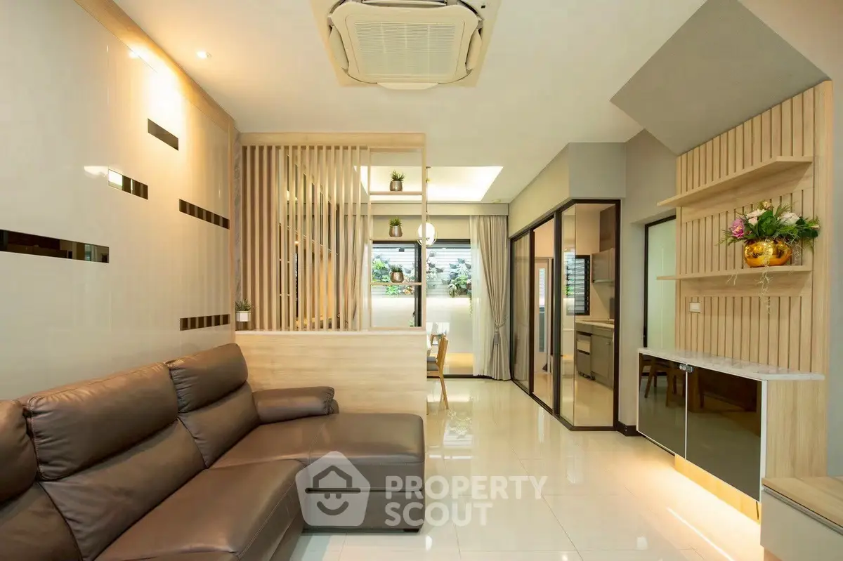 Modern living room with sleek design and open layout, featuring a leather sofa and stylish decor.