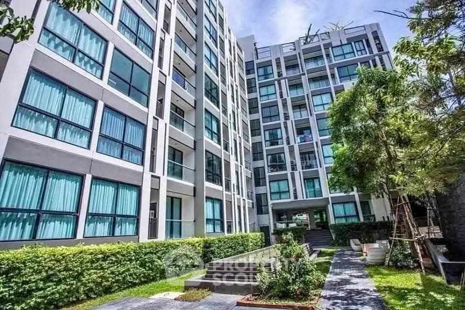 Modern apartment building with lush garden and pathway, ideal urban living.