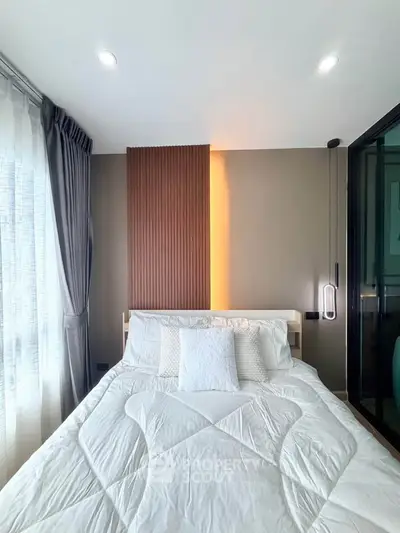 Modern bedroom with stylish decor and natural light, featuring a cozy bed and elegant curtains.