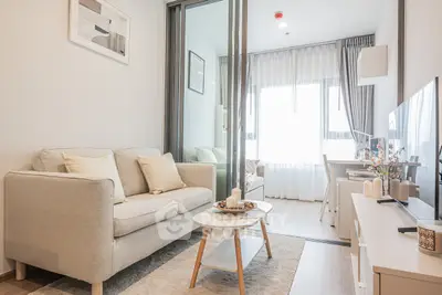 Modern living room with cozy sofa, stylish decor, and natural light in a contemporary apartment.