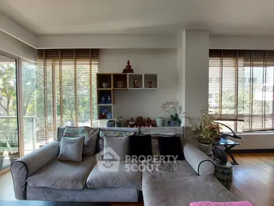 Spacious living room with large windows and cozy sofa, perfect for relaxation.