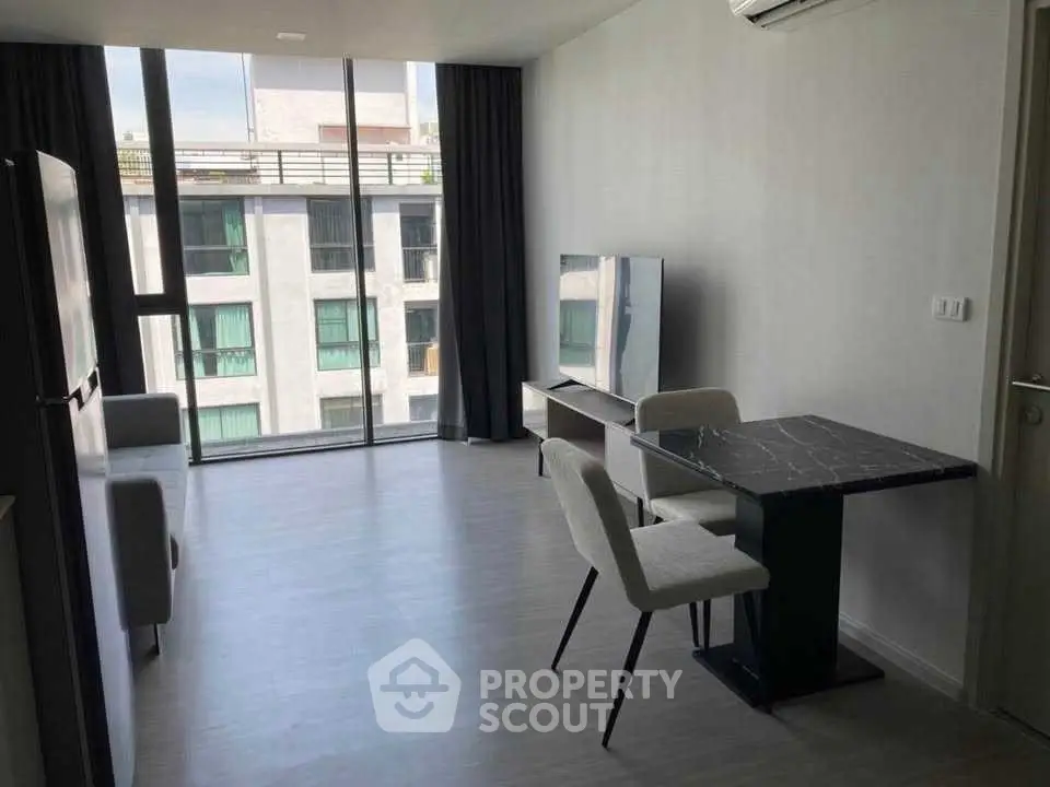 Modern living room with sleek furniture and large windows offering ample natural light.