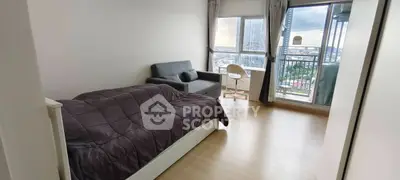 Modern bedroom with city view, featuring a cozy bed, sofa, and balcony access.