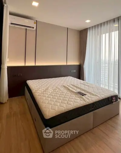 Spacious bedroom with modern design and large windows offering natural light.