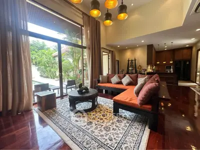 Luxurious living room with elegant decor and garden view, featuring wooden flooring and stylish lighting.