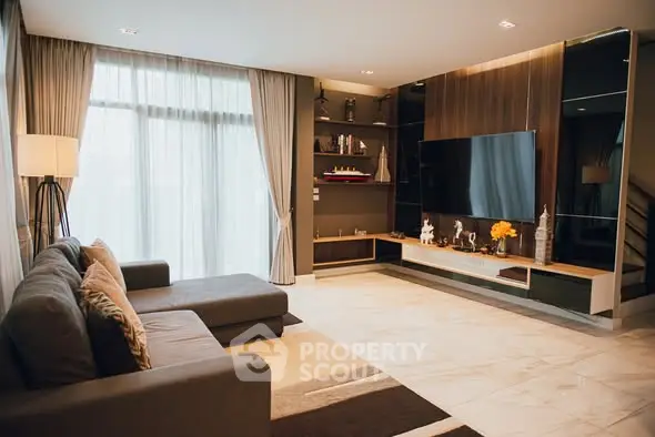 Spacious modern living room with large sofa and entertainment center.