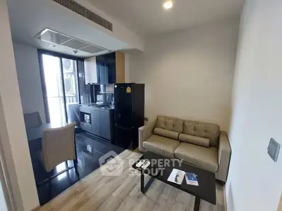 Modern compact living room with integrated kitchen and cozy seating area.